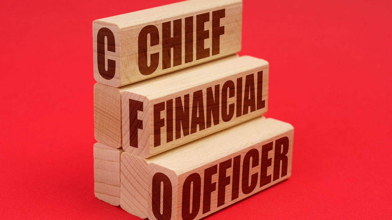 Wooden blocks with "CHIEF FINANCIAL OFFICER" written on them in black; red background Wooden blocks with "CHIEF FINANCIAL OFFICER" written on them in black; red background