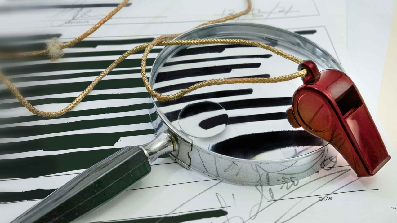 A redacted document with a magnifying glass and a whistle A redacted document with a magnifying glass and a whistle