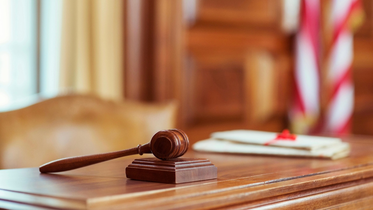 A gavel sitting on a judge's desk in a courtroom