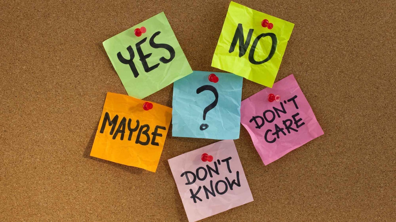 A corkboard with six post-it notes of various colors saying "yes," "no," "maybe," "don't know," and "don't care." A corkboard with six post-it notes of various colors saying "yes," "no," "maybe," "don't know," and "don't care."