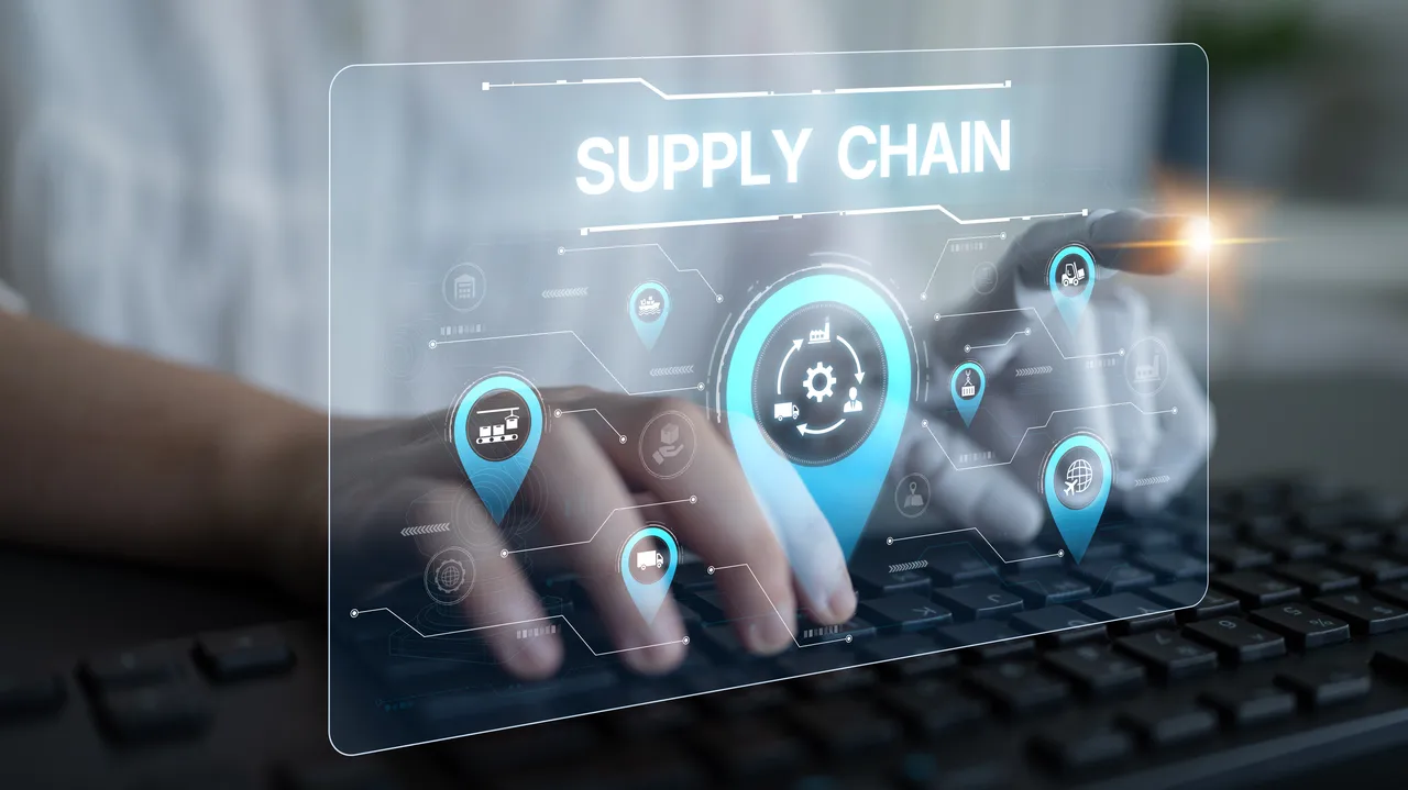 Hands typing on a keyboard with a digital interface overlay that says "Supply Chain."